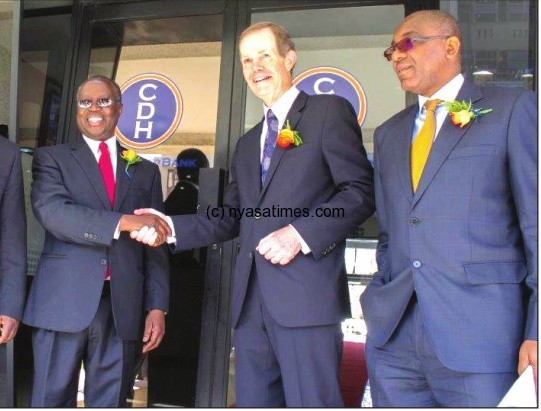 Reserve Bank of Malawi governor Charles Chuka shakes hands with CDH Investment bank board chair Franklin Kennedy