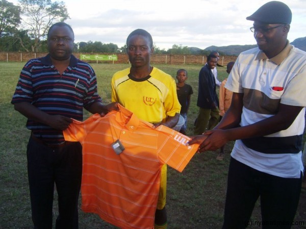 Ian Banda (centre) receives his man of the match award from TNM and Sulom representatives.