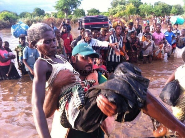 Lambat of Amra helping out an old woman flood-survivor