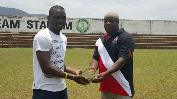 Bullets skipper Chiukepo Msowoya receiving the cash from top fan Mwamadi