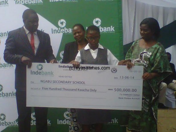 IndeBank's Maxwell Ng'ambi presents a dummy cheque to one of the beneficiaries Sandra Chimphonda as specialist teacher looks on