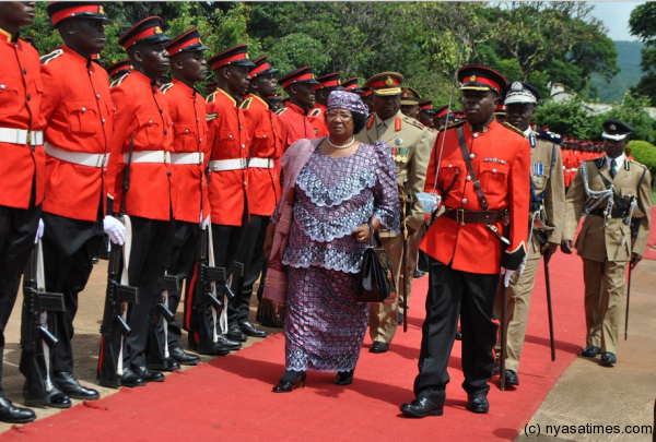 President Banda inspecting the guard of honour at Chileka international Airport before her departure to the UK.-Photo by Francis Mphweya