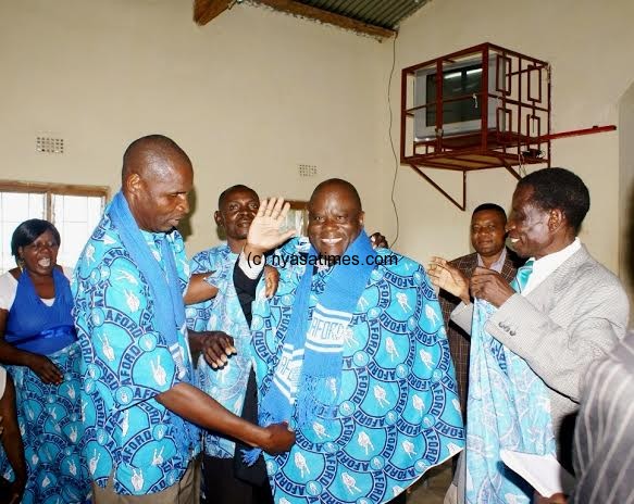 Kakhome- waving- being welcomed to the party by a Mr Kamoto and Makhuwa, AFORD Regional Chairmen for Central and Sourthern Regions respectively- Pic Chancy Gondwe