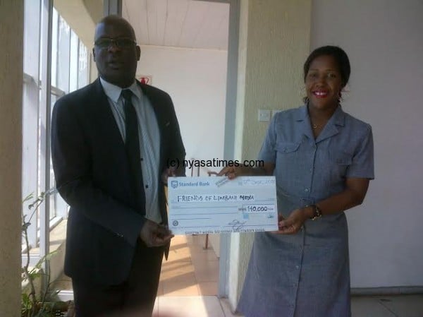 Kasakula receiving the cheque from FD Communications official Beatrice Fumba 