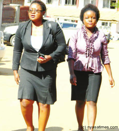 Katopola (left) coming out of court : To smile all the way to the bank