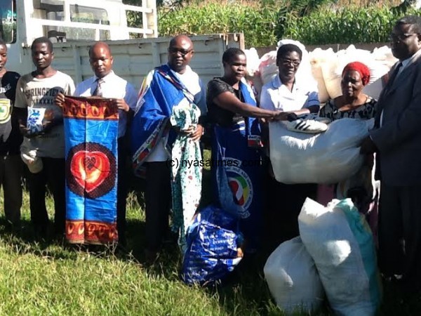 NONM project officer Mrs Harriet Chiomba handover the relief items.