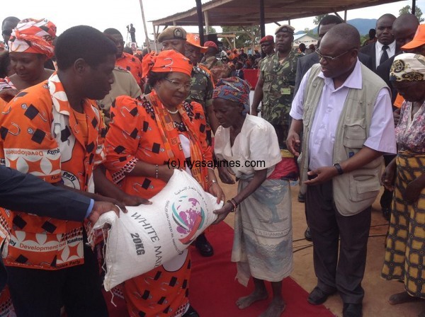 President Banda hands over maize flour to an old woman