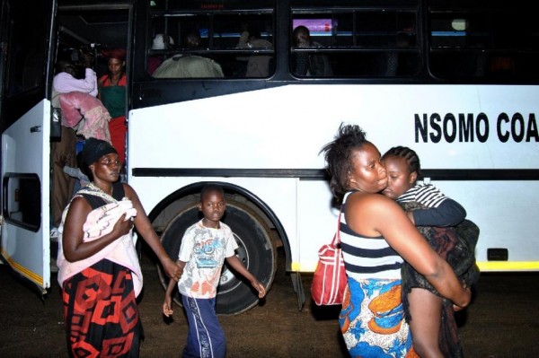 Malawians fleeing xenophobic violence in South Africa disembark a bus in Blantyre on April 20, 2015 after being repatriated (AFP Photo/Bonex Julius)