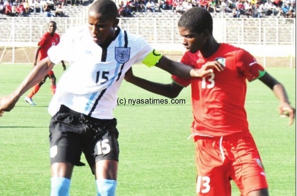 Malawi's U-20 star Mark Fodya in red  tackles Botswana's Mbaiwa