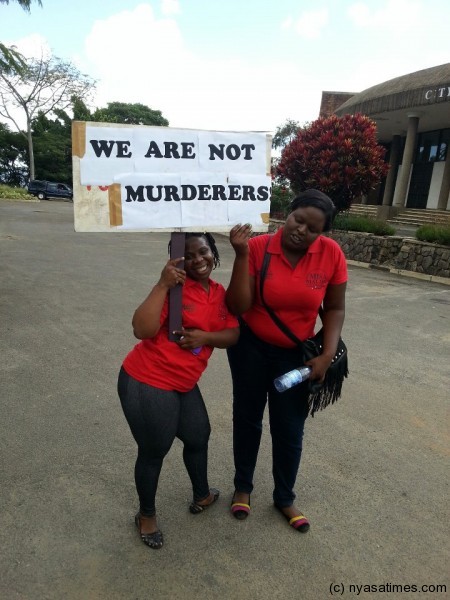 Blogger of the year Rabecca Chimjeka (L) carrying a placard to deny charges by Pres. Banda tht journalists killed late Pres. Bingu wa Mutharika