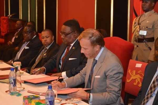 Momentous occasion: Malawi President Mutharika and Global Fund executive ditector Dybul put pen to paper on huge grant as Vice President Saulos Chilima and Finance Minister Goodall Gondwe witness