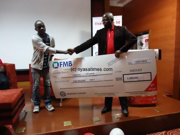 Mtumbuka presents a cheque to winner Thomas Banda