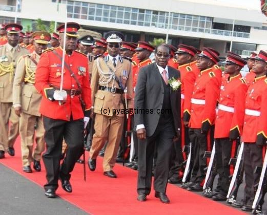 Mugabe inspect a guard of honour mounted by Malawi Defence Force on arrival in Lilongwe