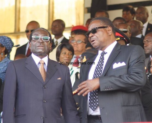 Mugabe and Mutharika chatting at independence celebrations.-Photo Mana