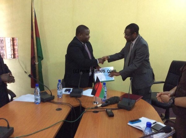Malawi's Information Minister Kondwani Nankhumwa receives the Cashgate report by UK firm Baker Tilly from Justice Minister Sam Tembenu. According to Tembenu, the report is in two parts, comprehensive and summarised. Photo by: Malawi News Agency