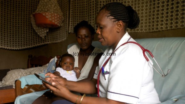 A nurse using  a mobile application offering real-time access to health data as a way to improve diagnosis and treatment of common diseases that afflict women and children. Photo by: GSK