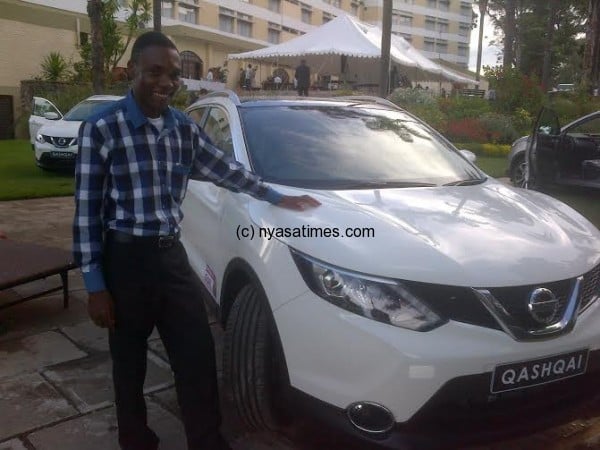    Assima in blue stripe shirt standing with his Qashqai