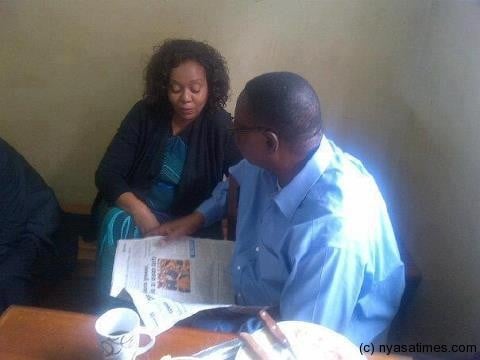 Peter Mutharika in the polic ecell being visited by a relation while reading a newspaper and having a full  English breakfast