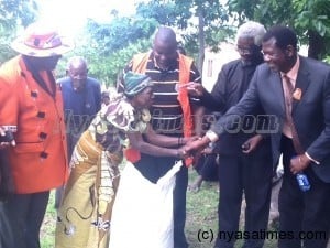 Malani donates maize to hailstorm victim in Karonga as Chief Kyungu looks on