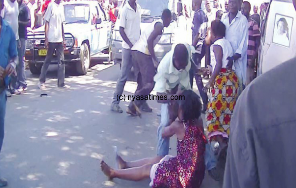 A photo taken by Times journalist Kasakura : A council official beating a woman in Limbe