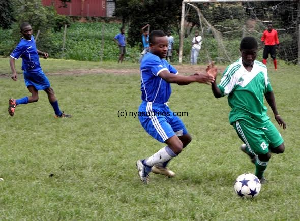 ESCOM and Manja Emirates players fighting for possession of the ball- Pic Lucky Mkandawire