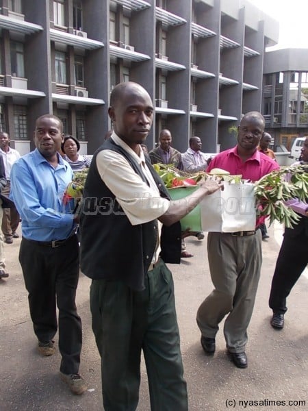 Striking civil servants carrying casket made of tree braches in their demo in Blantyre