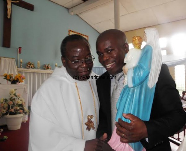 St Don Bosco Ward Chairman Oswald Mumba receiving the trophy from Parish Priest Father Benito Masuwa- Pic Lucky Mkandawire.