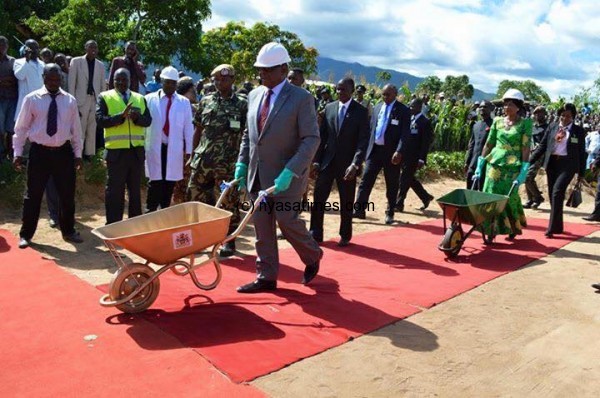 Mutharika pushing a barrow on red carpet