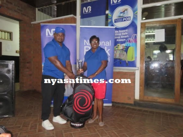 Charles Ulaya of National Bank presents a prize to Mkandawire.