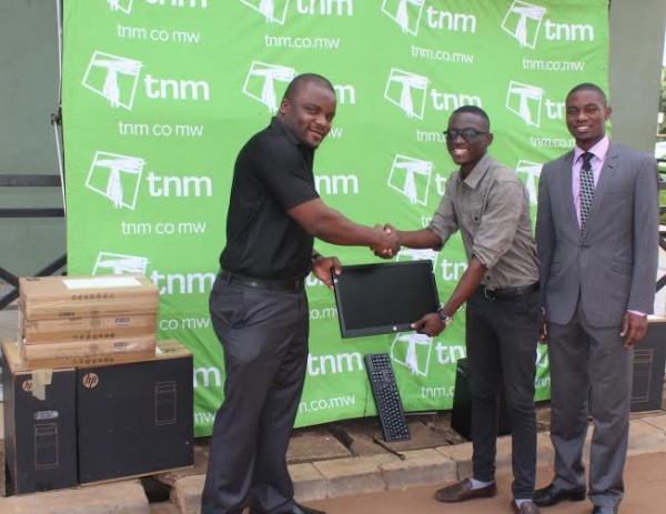 Malisita presenting a desk top monitor TO Mziya as one team member Pempho Khomba looks o