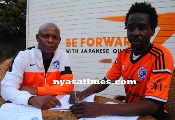 Right move: Harry completing a return to Wanderers with Butao witnessing the signing of the dotted lines