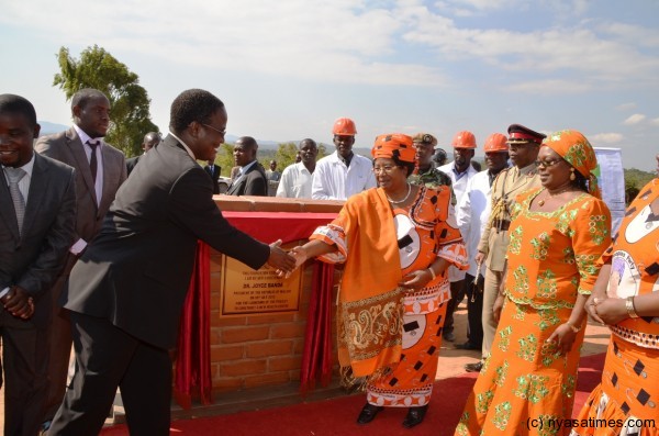 The President congratulates Dr. Charles Mwansambo, PS for Health after she unveiled the new Health Centre Plaque, as Health Minister Catherine Gotani Hara looks on