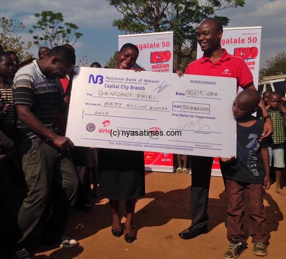 Celebration mode: Airtel's Charles Kamoto with the Winner and his family; Kamoto handing over a dummy cheque