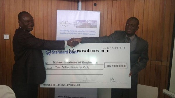 Solola Builders presenting the cheque to MIE